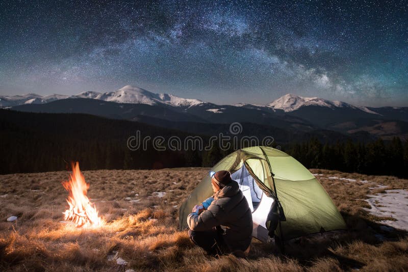Male tourist have a rest in his camping in the mountains at night under beautiful night sky full of stars and milky way royalty free stock images Male tourist have a rest in his camping in the mountains at night under beautiful night sky full of stars and milky way royalty free stock images