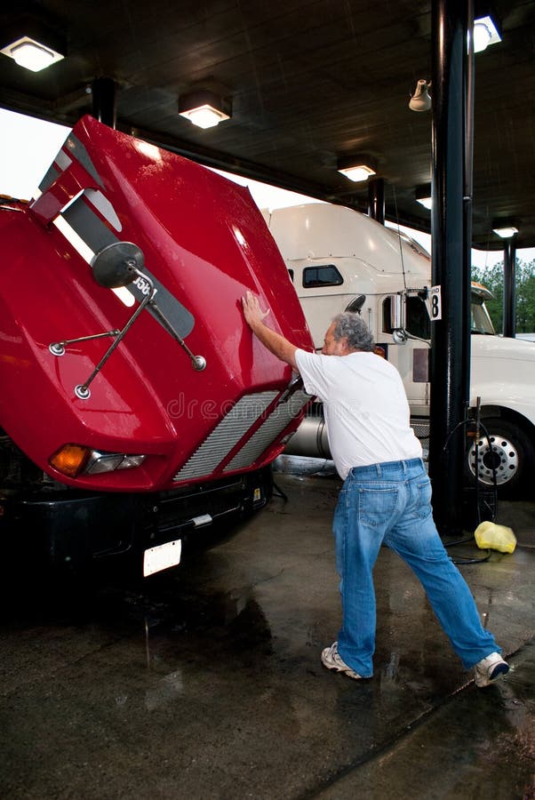 Male truck driver closing hood of 18-wheeler royalty free stock photos Male truck driver closing hood of 18-wheeler royalty free stock photos