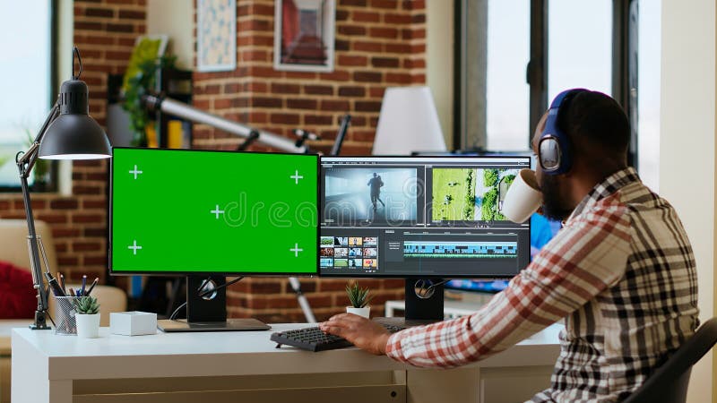 Male video editor works on movie project in creative software next to chroma key stock images