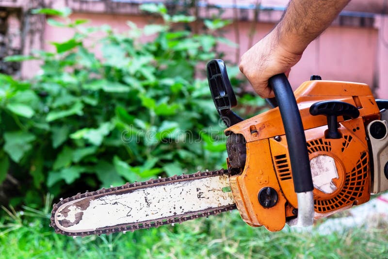 Male Worker Holding Small Chainsaw to Cutting Small Plants. stock images Male Worker Holding Small Chainsaw to Cutting Small Plants. stock images