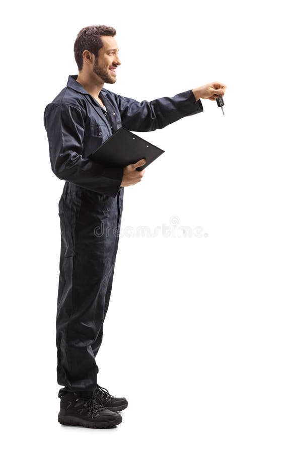 Male Worker Holding a Pile of Folded Clothes in Front of Clothing Racks ...