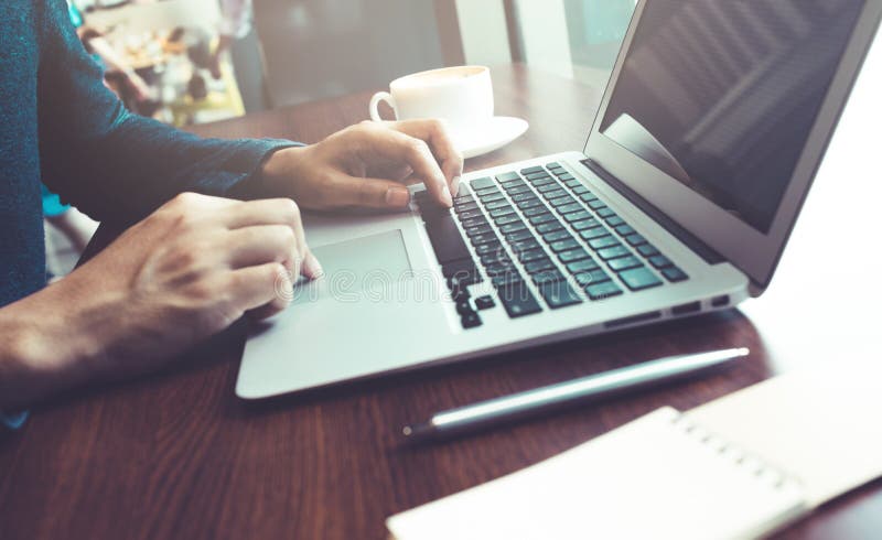 Male working with computer laptop on wood bar in cafe.Business lifestyle concepts ideas