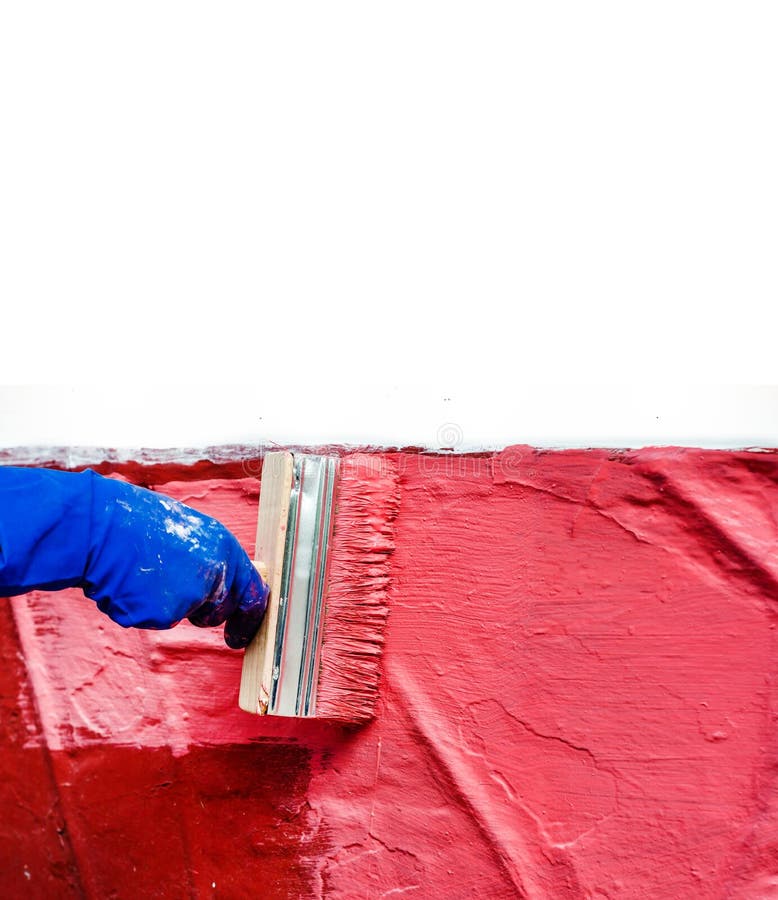 Malen Sie die Wand im Rot mit einem gro?en breiten Pinsel lizenzfreie stockfotos Malen Sie die Wand im Rot mit einem gro?en breiten Pinsel lizenzfreie stockfotos