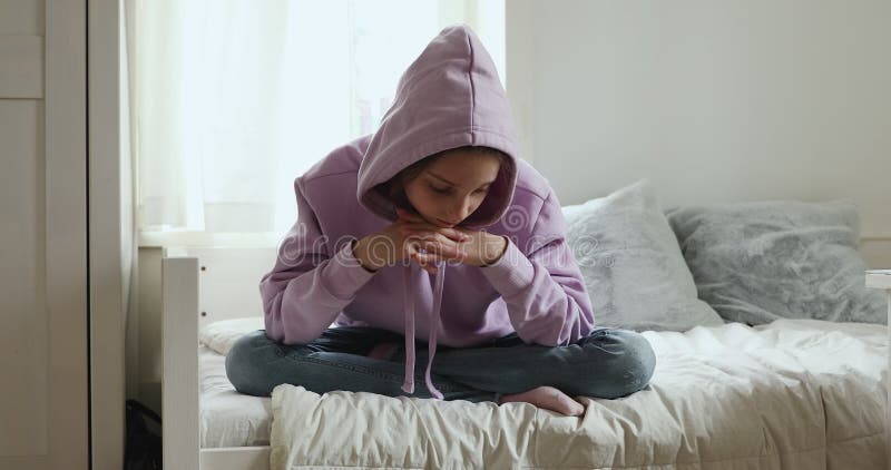Malheureuse d'adolescent assis sur le lit à réfléchir au problème clips vidéos