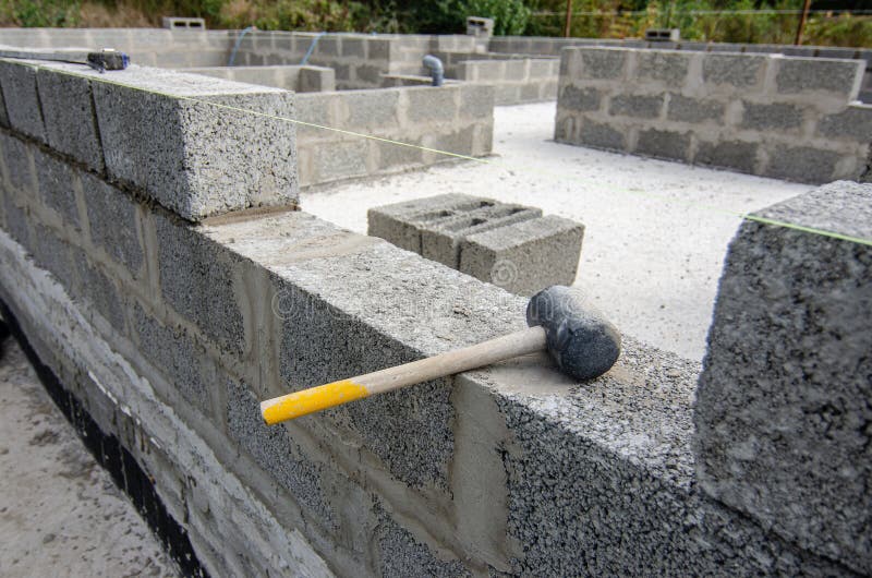 Mallet lies on part of the wall during the construction of a residential building stock image
