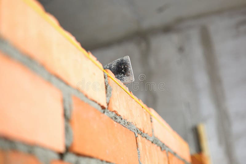 Mallet lying on top of brick wall as building and renovation stock image