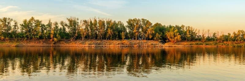 Malowniczy letni panoramiczny krajobraz z brzegiem rzeki o zachodzie słońca. spokojne odbicie rzeki w wodzie. wspaniała natura obrazy royalty free