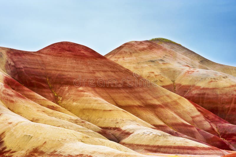 One of the seven wonders of Oregon the Painted Hills in the John Day Fossil Bed National Monument. It`s colorful layers of textured claystone formed after millions of years by different volcanic eruptions. One of the seven wonders of Oregon the Painted Hills in the John Day Fossil Bed National Monument. It`s colorful layers of textured claystone formed after millions of years by different volcanic eruptions.