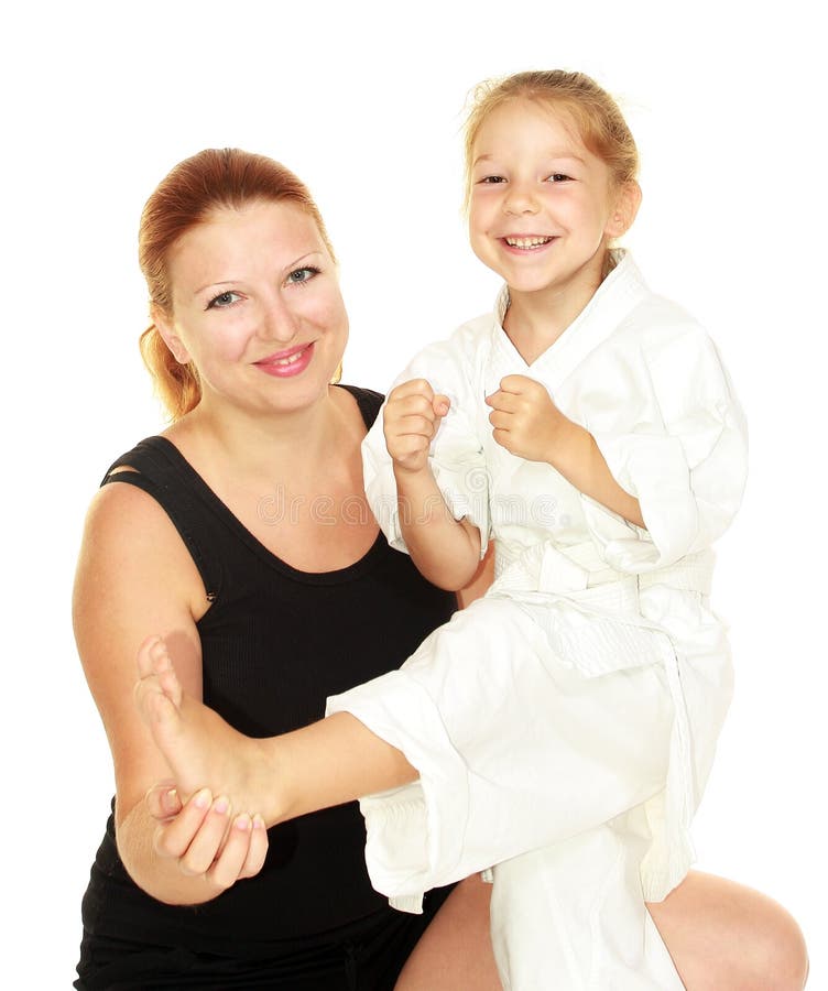 Mama uczy córki ubierającej w kimonowym karate kopnięciu izolującym zdjęcie royalty free Mama uczy córki ubierającej w kimonowym karate kopnięciu izolującym zdjęcie royalty free