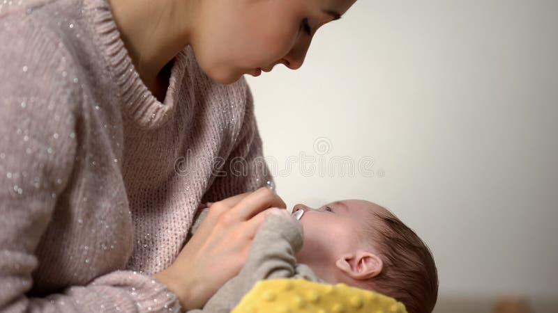 Maman donnant ? peu d'enfant adorable les accessoires orthodontiques d'enfants binky et nouveau-n?s images stock Maman donnant ? peu d'enfant adorable les accessoires orthodontiques d'enfants binky et nouveau-n?s images stock