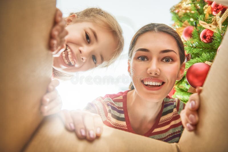 Maman et fille ouvrant un cadeau de Noël image libre de droits Maman et fille ouvrant un cadeau de Noël image libre de droits