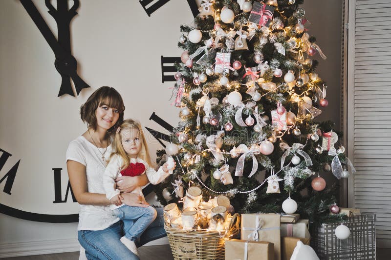 Maman et sa fille sur le fond de grandes montres de blanc et de ch image stock