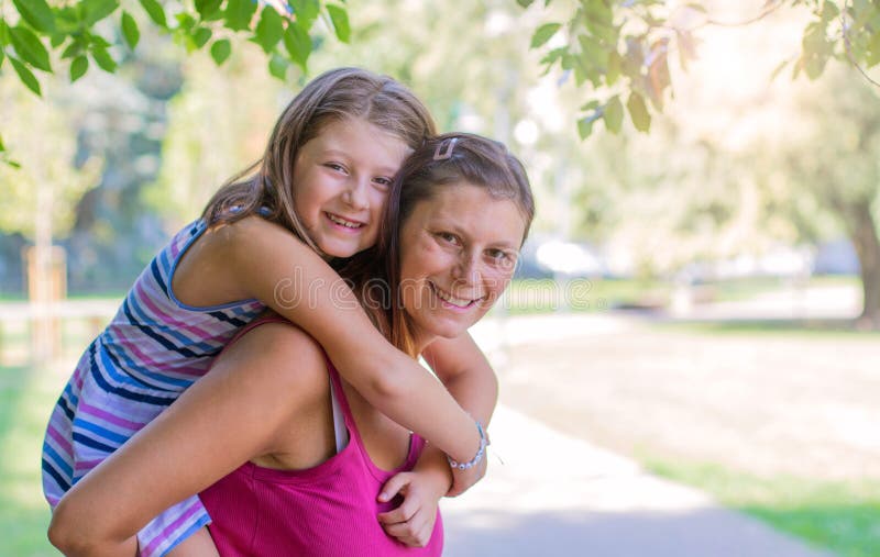 Maman jouant avec son enfant dehors en parc dans un jour ensoleillé photo stock Maman jouant avec son enfant dehors en parc dans un jour ensoleillé photo stock