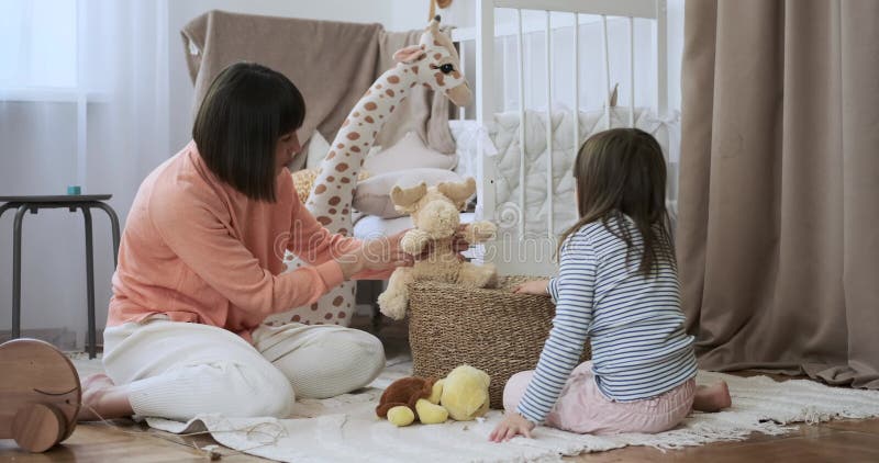 Maman joue avec sa fille par terre dans la chambre des enfants banque de vidéos