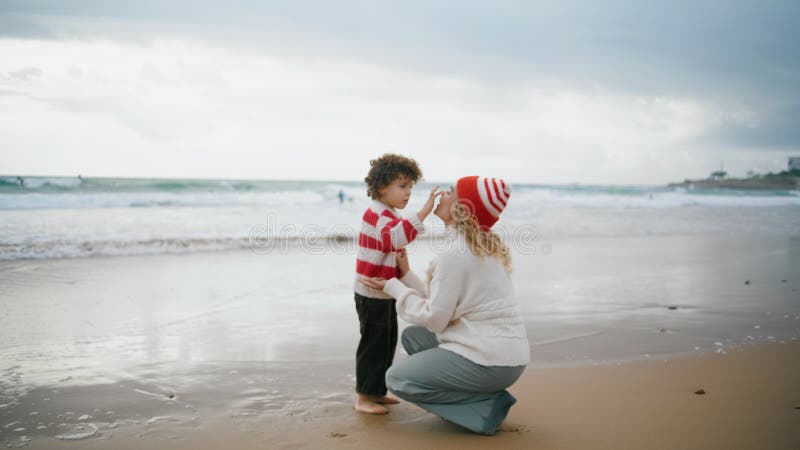 Maman son reposant au bord de la mer le week-end d'automne. adorable petit garçon touchant mère