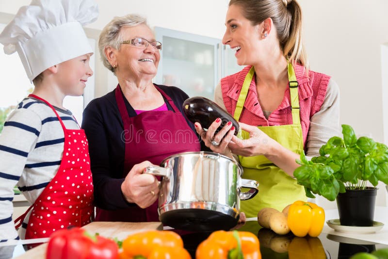 Mamie Maman Et Fils Parlant Tout En Faisant Cuire Dans La Cuisine 