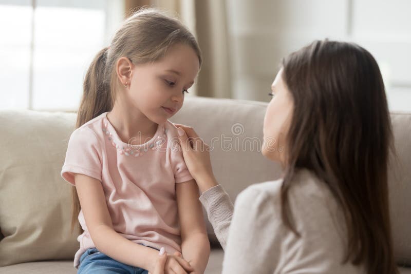 Mamma di amore che parla per rovesciare poca ragazza del bambino che dà supporto immagine stock libera da diritti