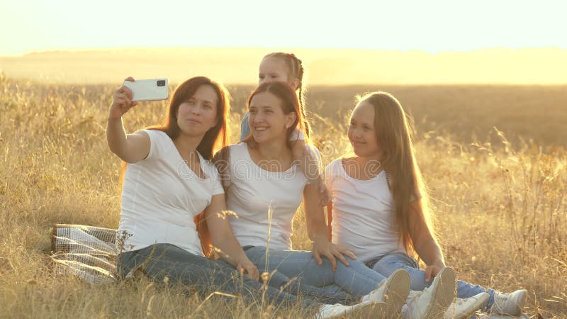 Mamma e bambini felici vengono fotografati su uno smartphone Madre e figlia si fanno un selfie mentre viaggiano archivi video