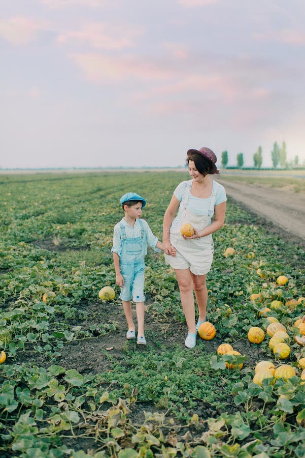 Mamma e figlio su un campo con i meloni