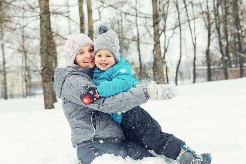 Mamma e piccolo figlio che giocano nella neve fotografia stock libera da diritti Mamma e piccolo figlio che giocano nella neve fotografia stock libera da diritti