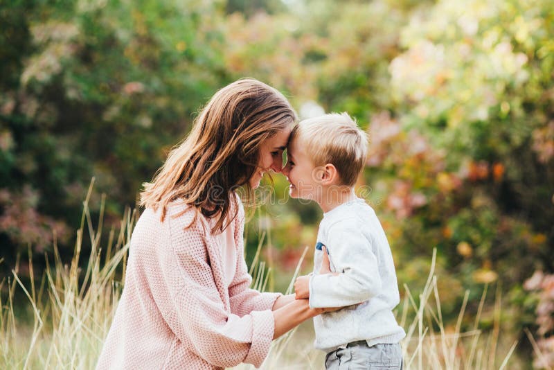 Mamma ed abbraccio e risata del figlio nel parco di autunno Spazio per testo fotografia stock libera da diritti Mamma ed abbraccio e risata del figlio nel parco di autunno Spazio per testo fotografia stock libera da diritti