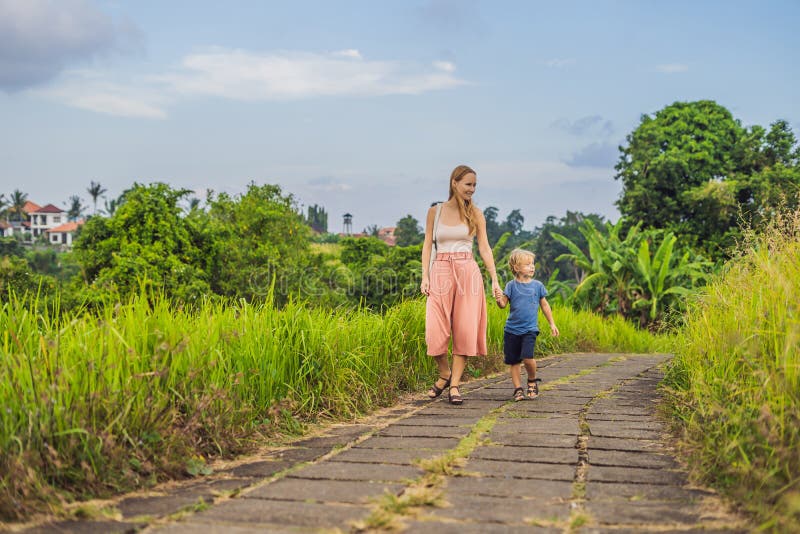 Mom and son tourists in Campuhan Ridge Walk , Scenic Green Valley in Ubud Bali. Traveling with children concept. Mom and son tourists in Campuhan Ridge Walk , Scenic Green Valley in Ubud Bali. Traveling with children concept.