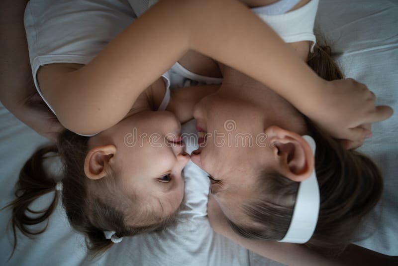 Mamma och dotter har kul i sovrummet fotografering för bildbyråer