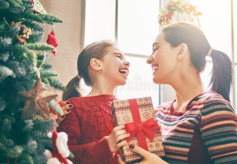 Mamma och dotter nära julgranen fotografering för bildbyråer