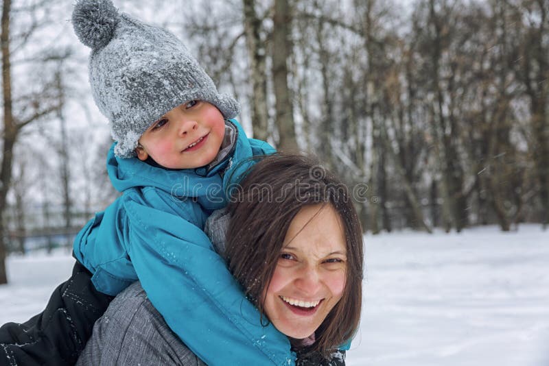 Mamma och liten son som spelar i den insnöade vintern royaltyfri bild Mamma och liten son som spelar i den insnöade vintern royaltyfri bild