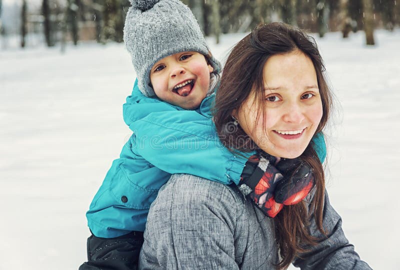 Mamma och liten son som spelar i snön arkivfoto Mamma och liten son som spelar i snön arkivfoto