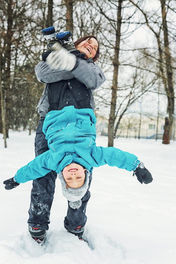 Mamma och liten son som spelar i snön arkivfoto Mamma och liten son som spelar i snön arkivfoto