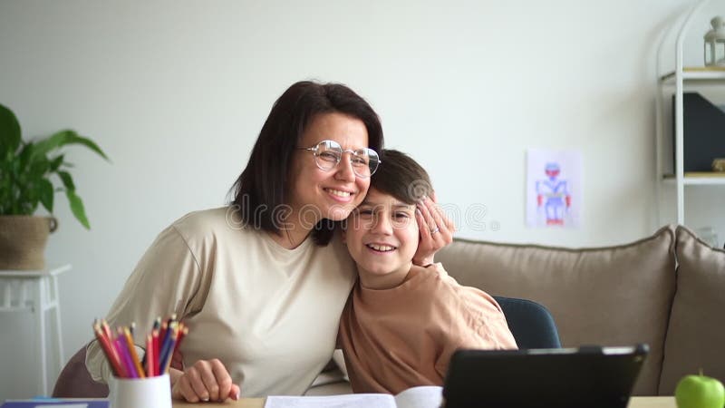 Mamma och son gör läxor och tittar på kameran.. glad modern familjefejson med 40-tal arkivfilmer