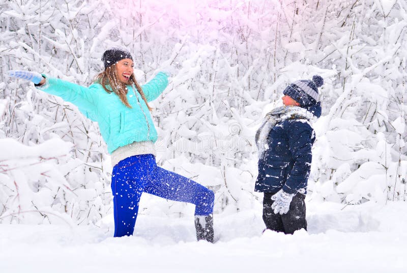 Mamma- och sonkastsnö upp i en snöig vinter att parkera royaltyfria foton