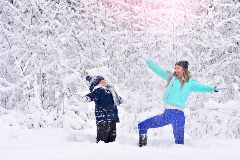 Mamma- och sonkastsnö upp i en snöig vinter att parkera fotografering för bildbyråer