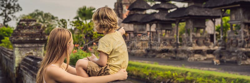 Mamma- och sonturister i den hinduiska templet Taman Ayun för traditionell balinese i Mengwi Bali Indonesien resande med barnbegr fotografering för bildbyråer Mamma- och sonturister i den hinduiska templet Taman Ayun för traditionell balinese i Mengwi Bali Indonesien resande med barnbegr fotografering för bildbyråer