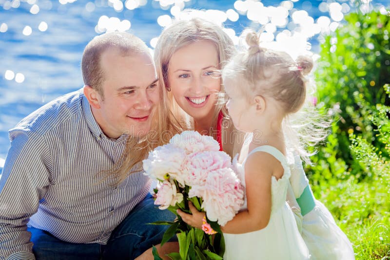 Mamma, papa en dochter gelukkig op de achtergrond van blauw water royalty-vrije stock afbeelding Mamma, papa en dochter gelukkig op de achtergrond van blauw water royalty-vrije stock afbeelding