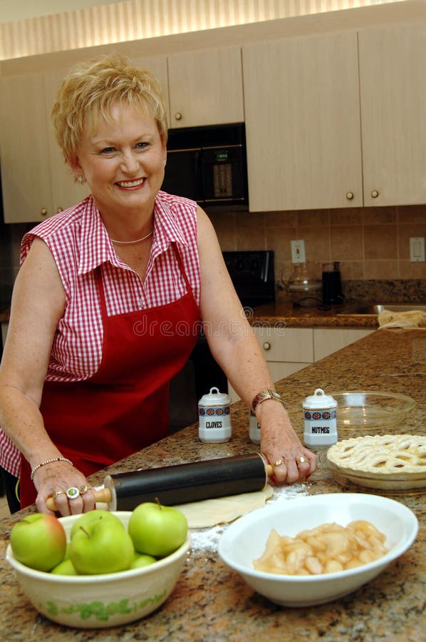 As american as Mom and apple pie, a senior woman making an apple pie at home in her kitchen. As american as Mom and apple pie, a senior woman making an apple pie at home in her kitchen.