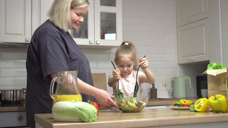 Mamma överför familjens mattraditioner till sin dotter genom att laga grönsaker tillsammans arkivfilmer