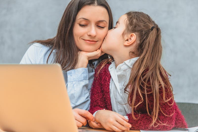 Mamman och skolflickan sitter p? tabellen Närbild av moders ögon som stänger sig på ögonen av hennes dotter ?rligt royaltyfri fotografi Mamman och skolflickan sitter p? tabellen Närbild av moders ögon som stänger sig på ögonen av hennes dotter ?rligt royaltyfri fotografi