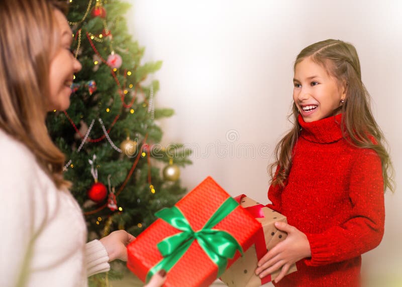 Mamá alegre y su muchacha linda de la hija que intercambian los regalos Feliz Navidad y buenas fiestas fotos de archivo Mamá alegre y su muchacha linda de la hija que intercambian los regalos Feliz Navidad y buenas fiestas fotos de archivo