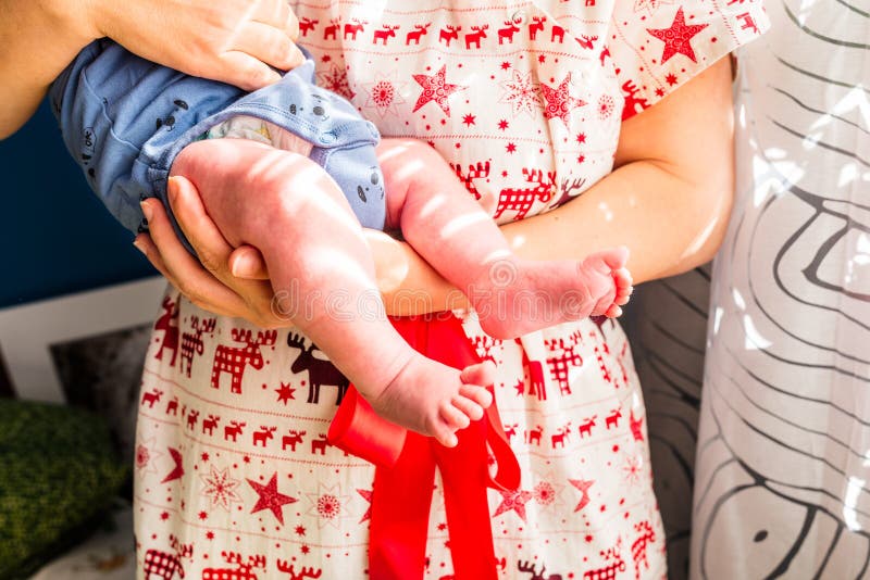 Mother holding her baby boy wearing a red reindeer dress. Mother holding her baby boy wearing a red reindeer dress.