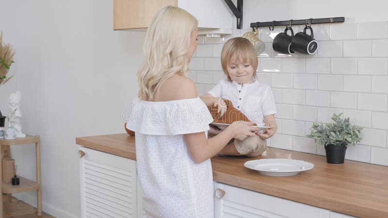 Mamá e hijo en una cocina luminosa. juntos las tareas del hogar son más divertidas.