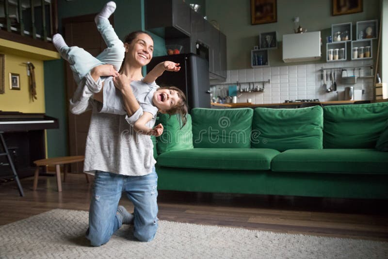 Mamá o niñera feliz que juega con la muchacha del niño en casa imagen de archivo libre de regalías Mamá o niñera feliz que juega con la muchacha del niño en casa imagen de archivo libre de regalías