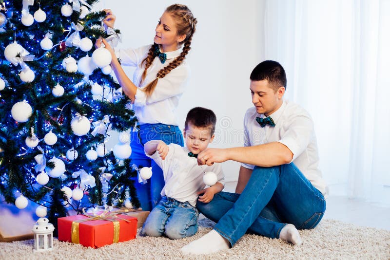 Mamá padre e hijo decoran los regalos de los árboles de Navidad árboles de nuevo año vacaciones de invierno Garland imágenes de archivo libres de regalías