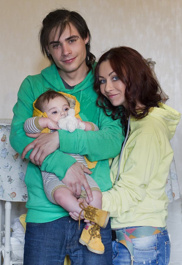 Mamá, papá e hijo jovenes de la familia en casa fotos de archivo