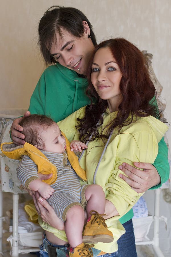 Mamá, papá e hijo jovenes de la familia en casa imagenes de archivo
