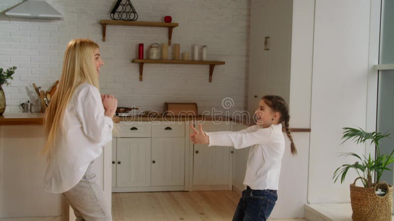 Mamá y su hija bailando el domingo por la mañana pasándola bien juntos. buena relación madre-hija. madres almacen de metraje de vídeo