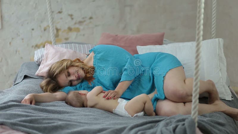 Mamã bonita que beija seu bebê de sono