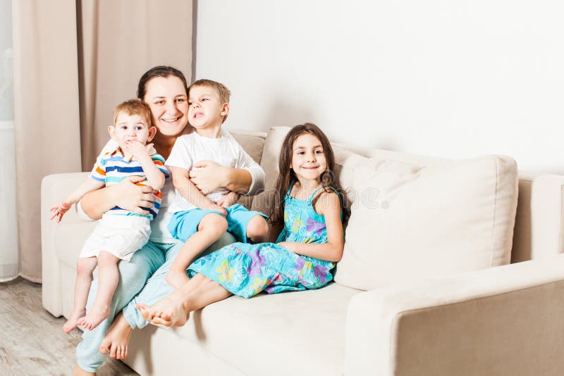 Mamã com suas crianças que sentam-se e que levantam para uma foto de família foto de stock royalty free Mamã com suas crianças que sentam-se e que levantam para uma foto de família foto de stock royalty free