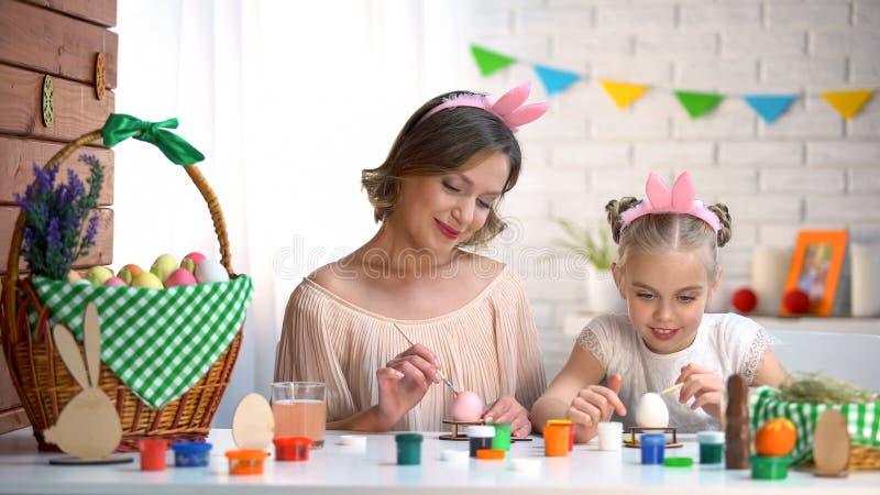 Mamã e menina nas faixas que colorem ovos para a Páscoa, relações fortes tornando-se fotos de stock Mamã e menina nas faixas que colorem ovos para a Páscoa, relações fortes tornando-se fotos de stock